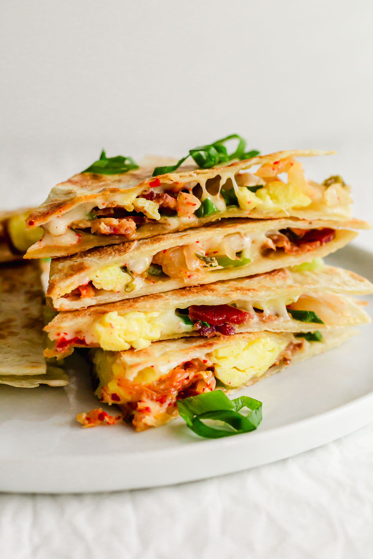 A stack of quesadillas on a white plate.