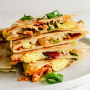 A stack of quesadillas on a white plate.