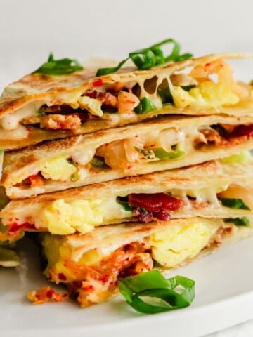 A stack of quesadillas on a white plate.