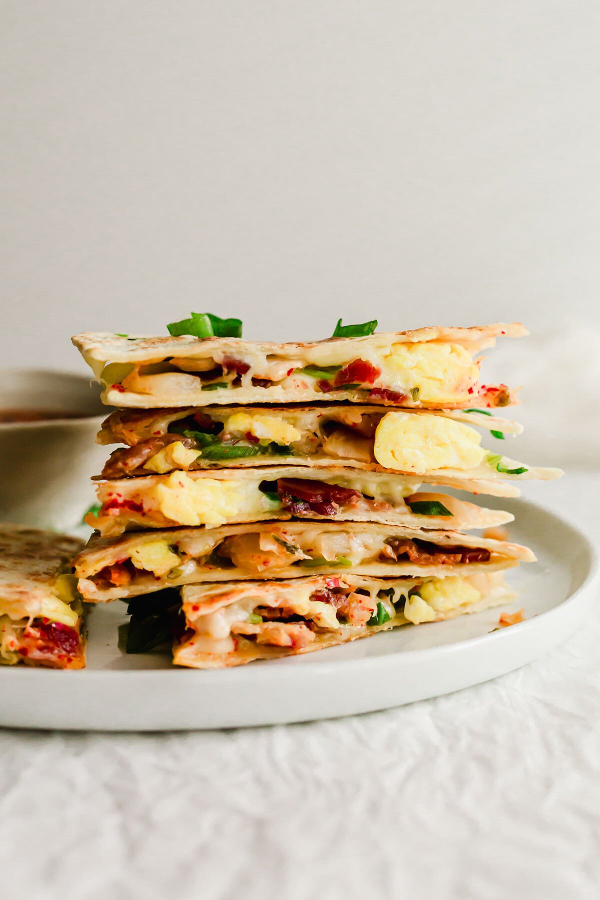 A stack of quesadillas on a white plate.