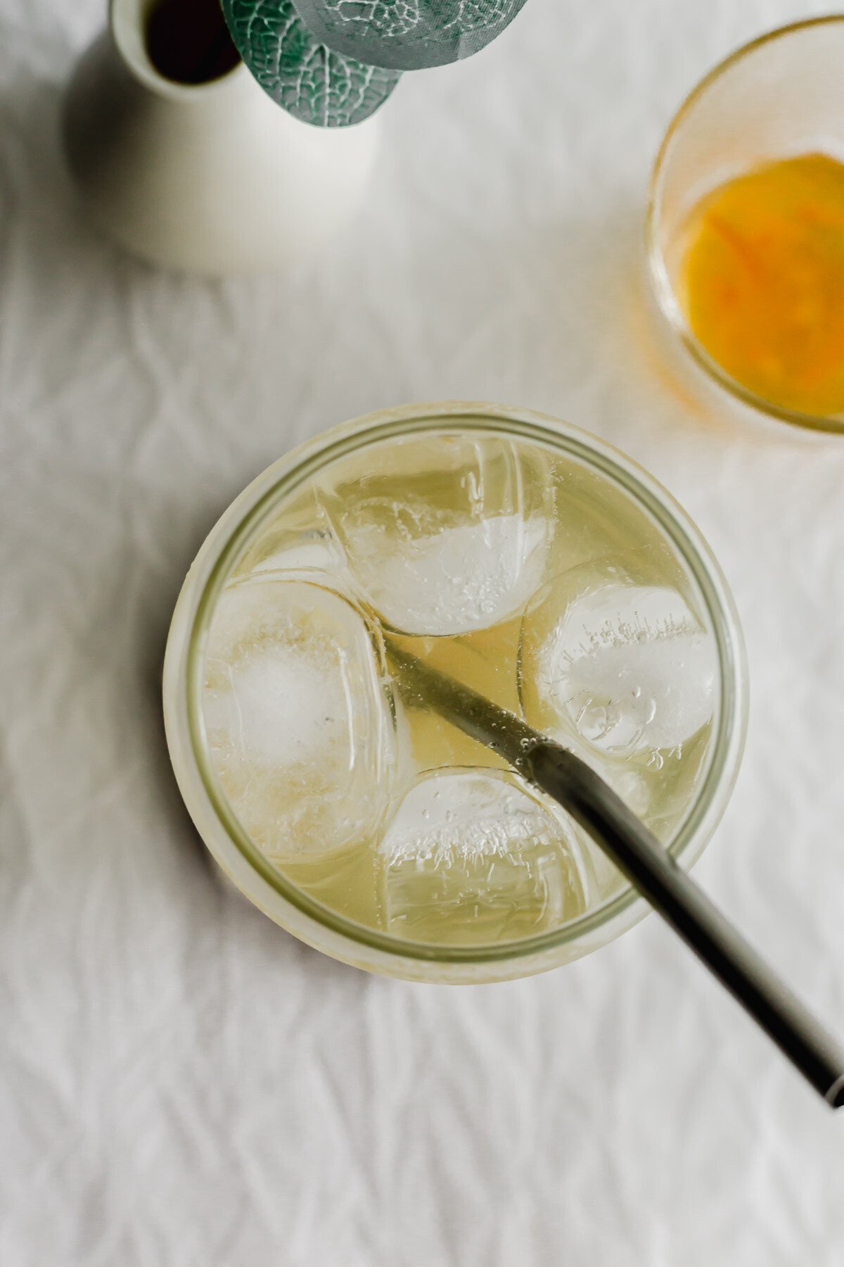 Iced sparkling yuzu in a glass with metal straw.