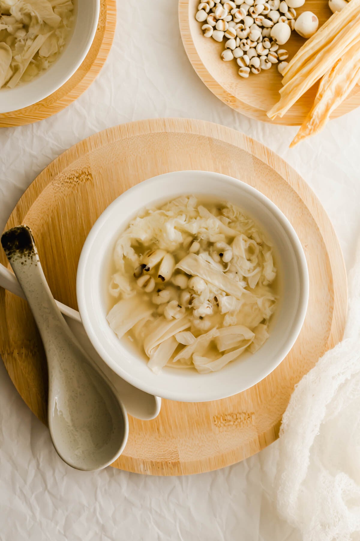Chinese Job's tears dessert soup in a white bowl with spoons on the side.