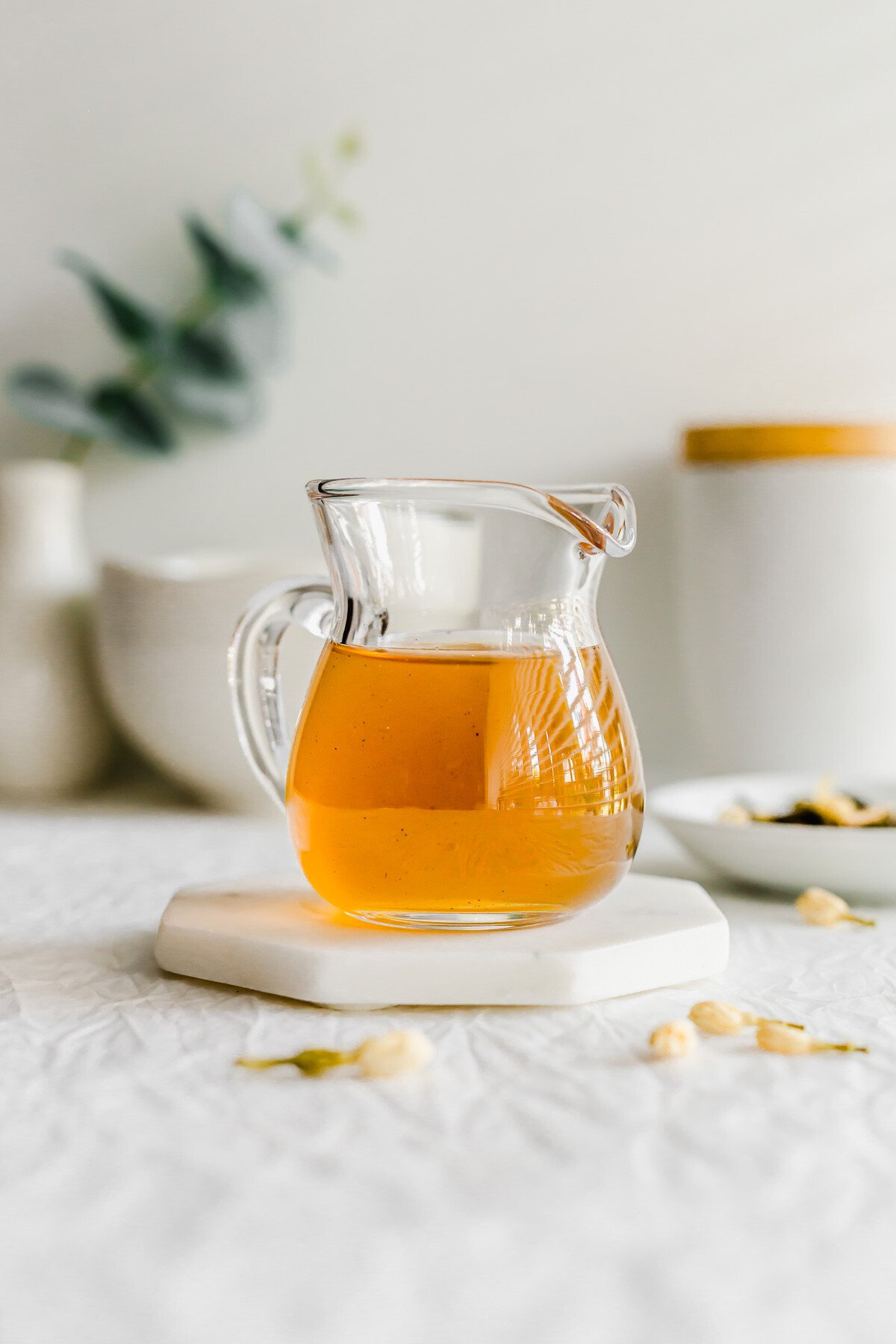 A glass pitcher filled with jasmine syrup.