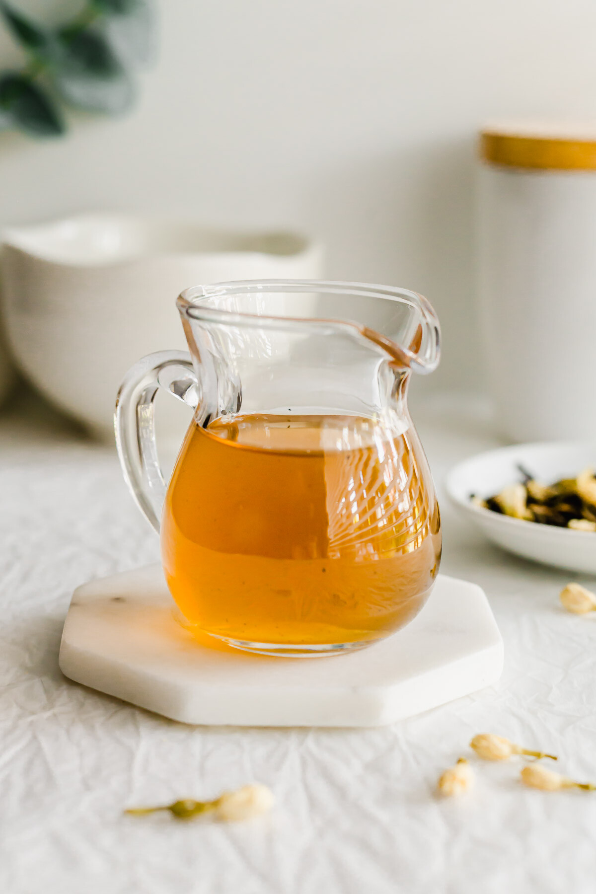 A glass pitcher filled with jasmine syrup.