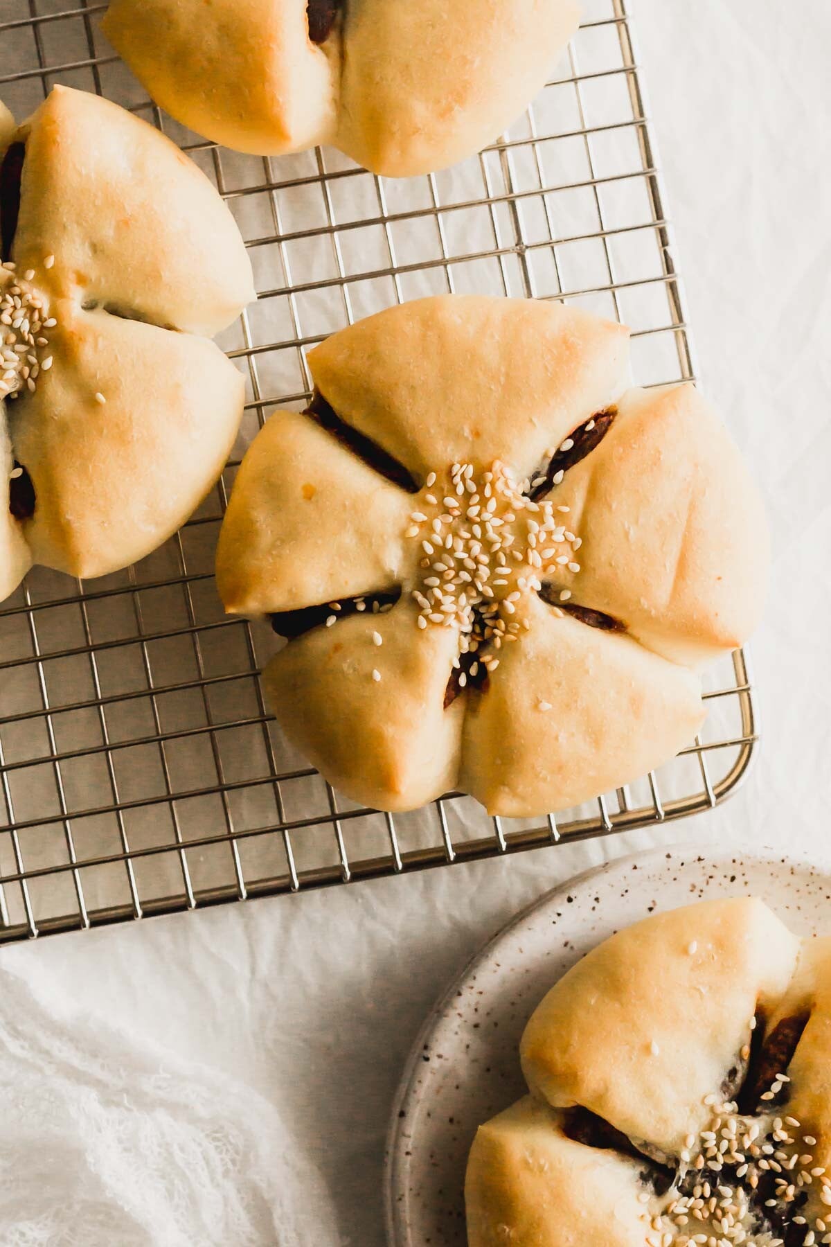 Flower red bean buns on a wire rack.