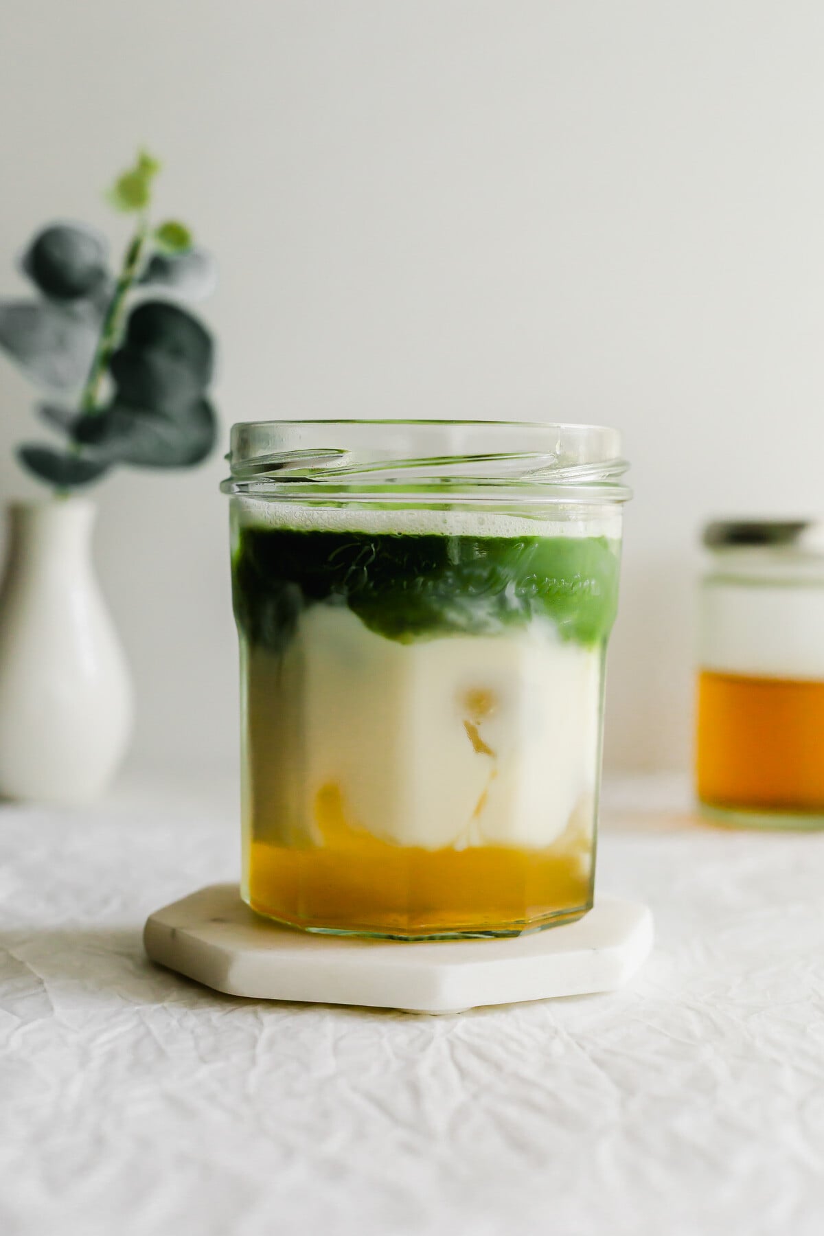 A glass of layered jasmine matcha latte.