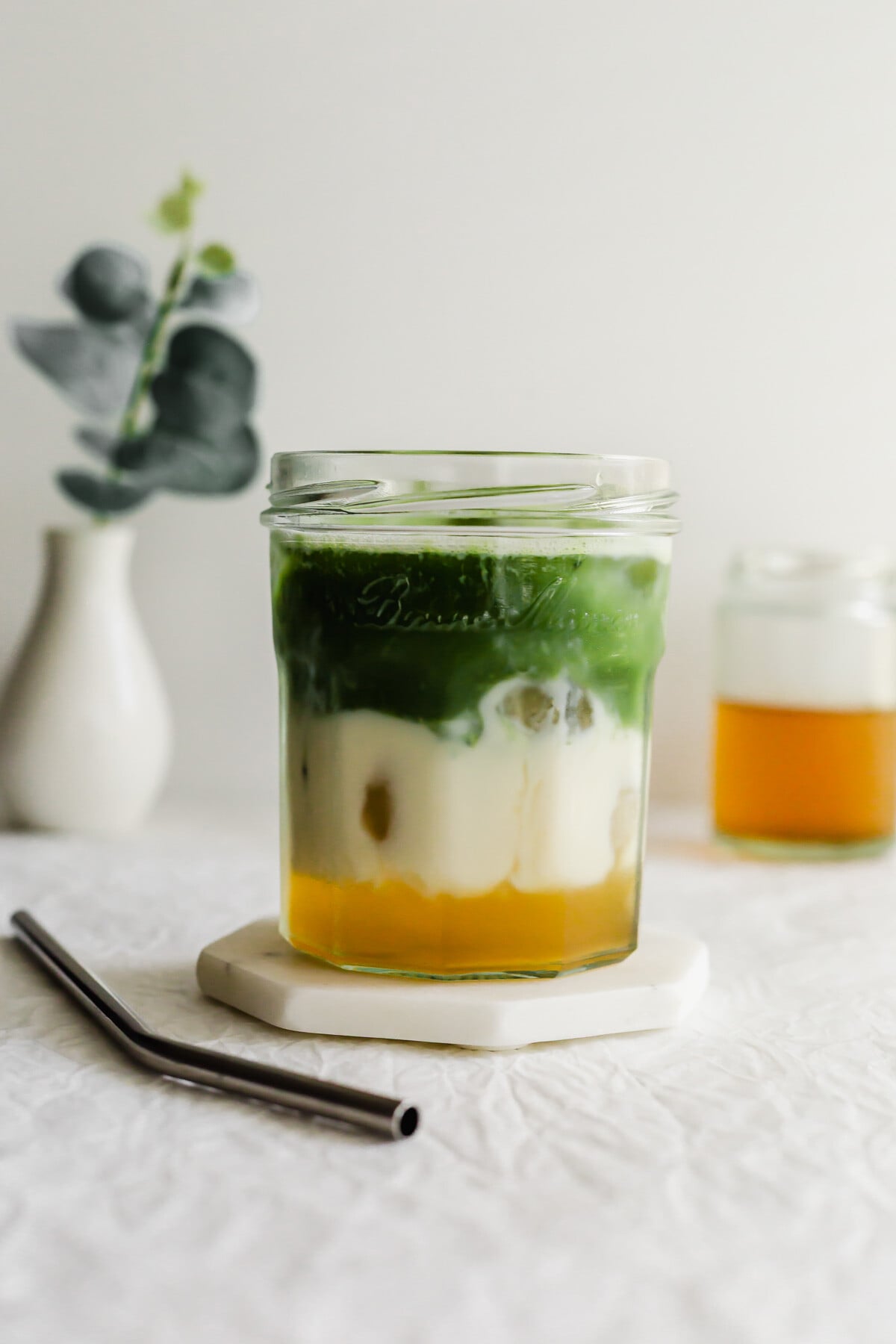 A glass of layered jasmine matcha latte.