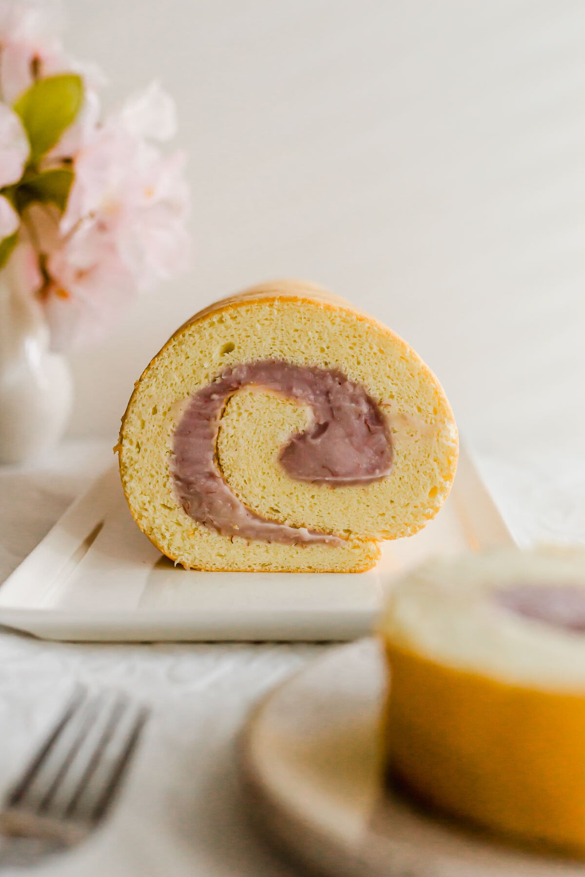 Taro roll cake on a white plate.