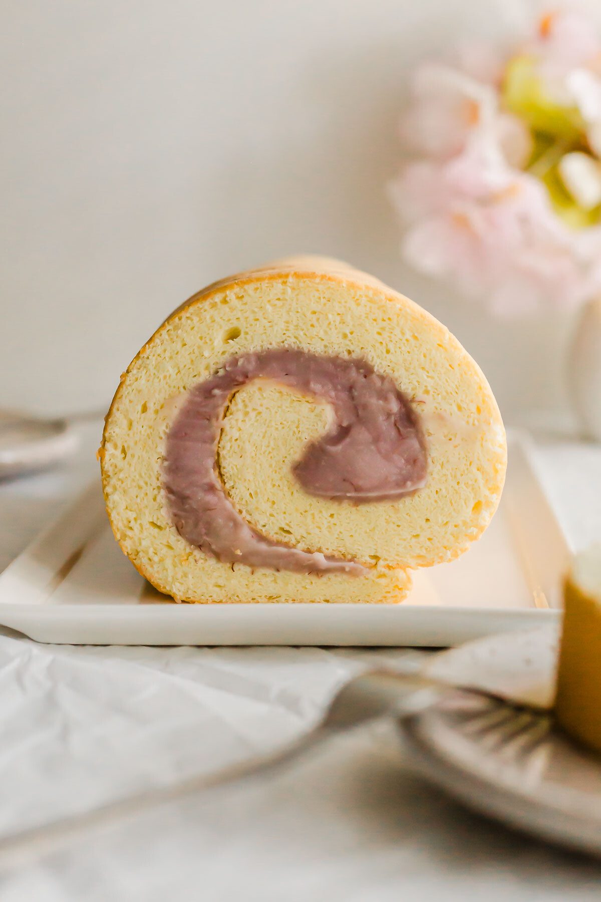 Taro roll cake on a white plate.