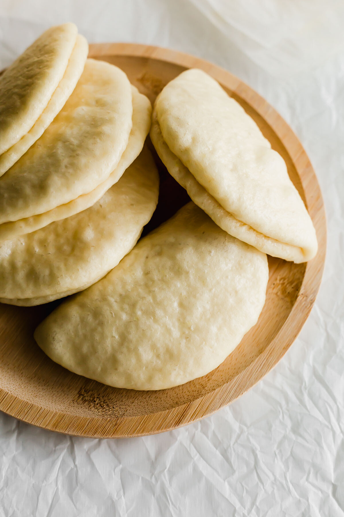 Chinese bao buns on a wooden plate.