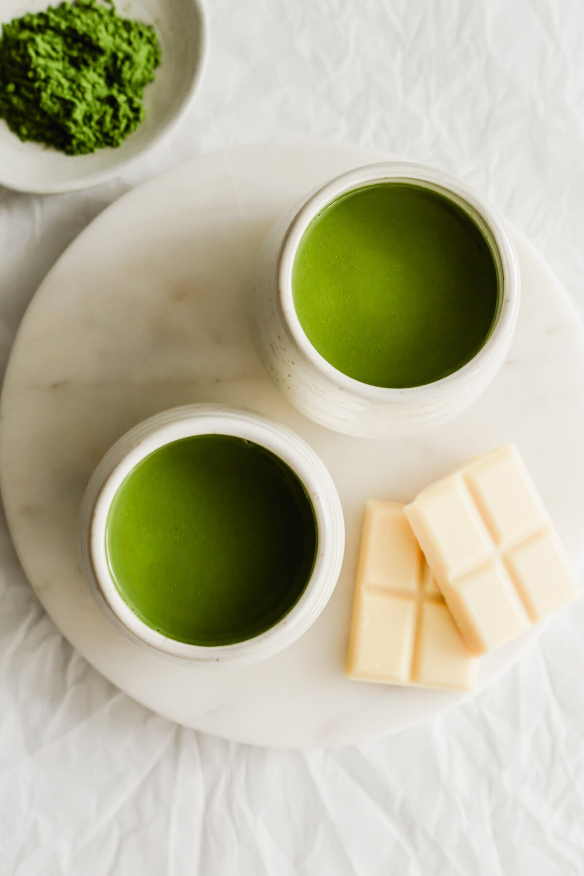 Matcha white hot chocolate in 2 white mugs.