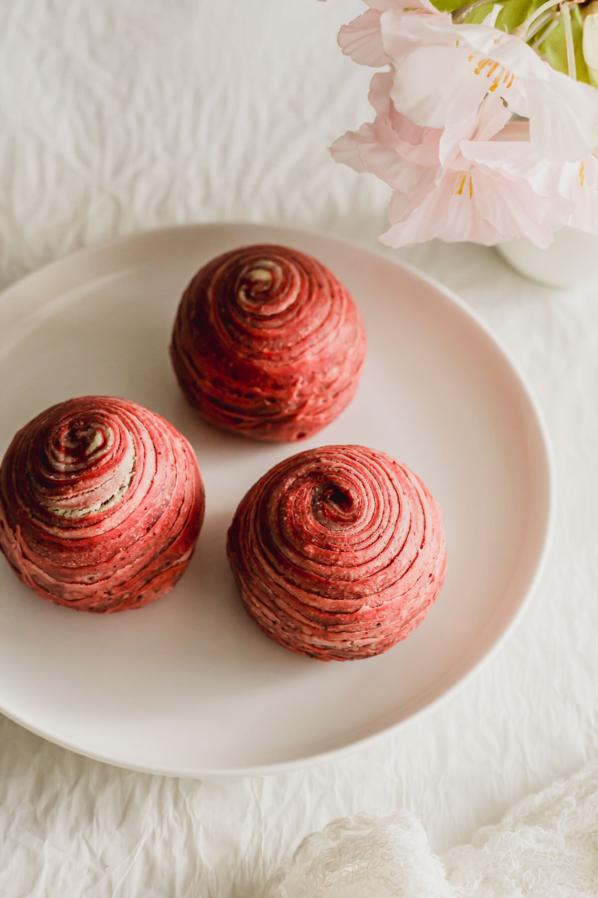Red Teochew spiral mooncakes on a white plate.