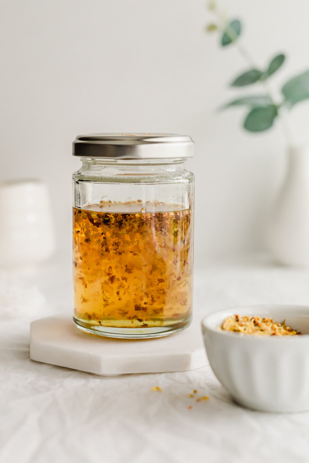 Osmanthus syrup in a glass jar with lid.