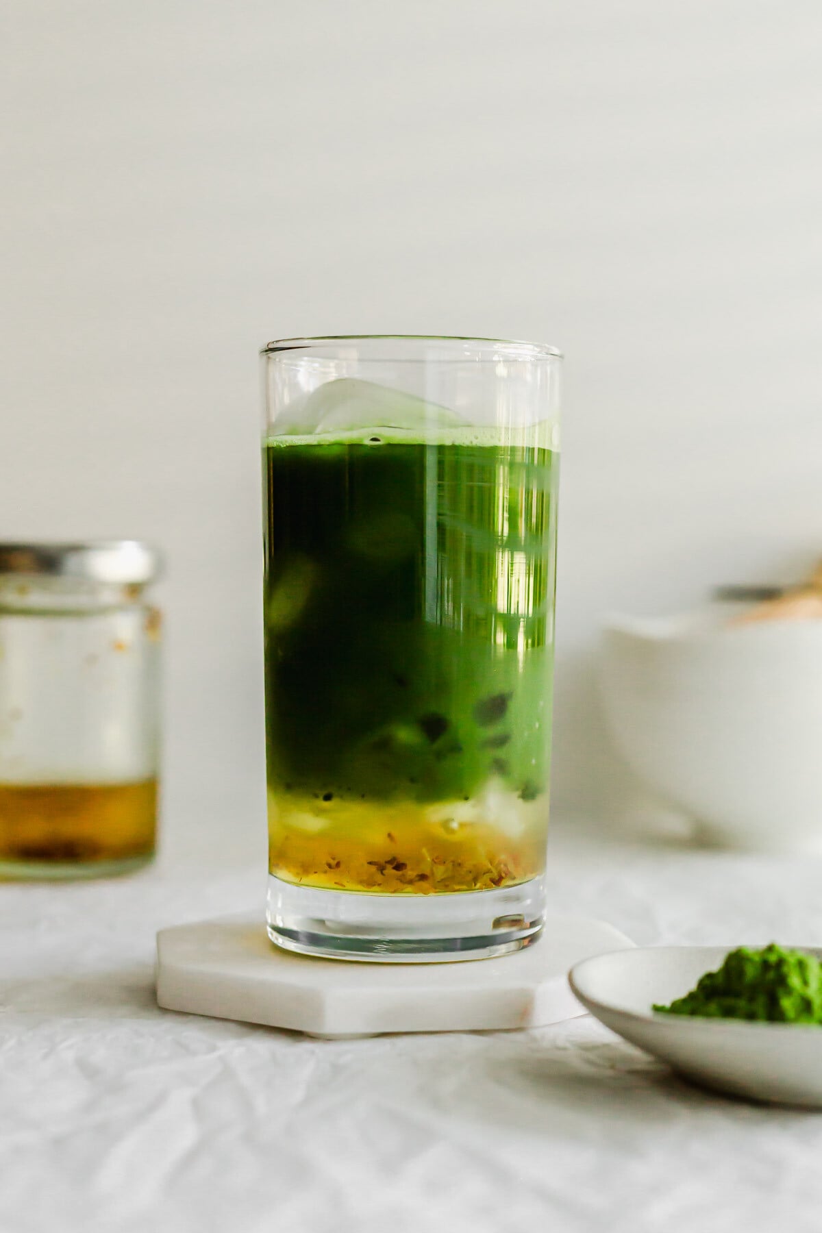 Matcha osmanthus tea in a tall glass.