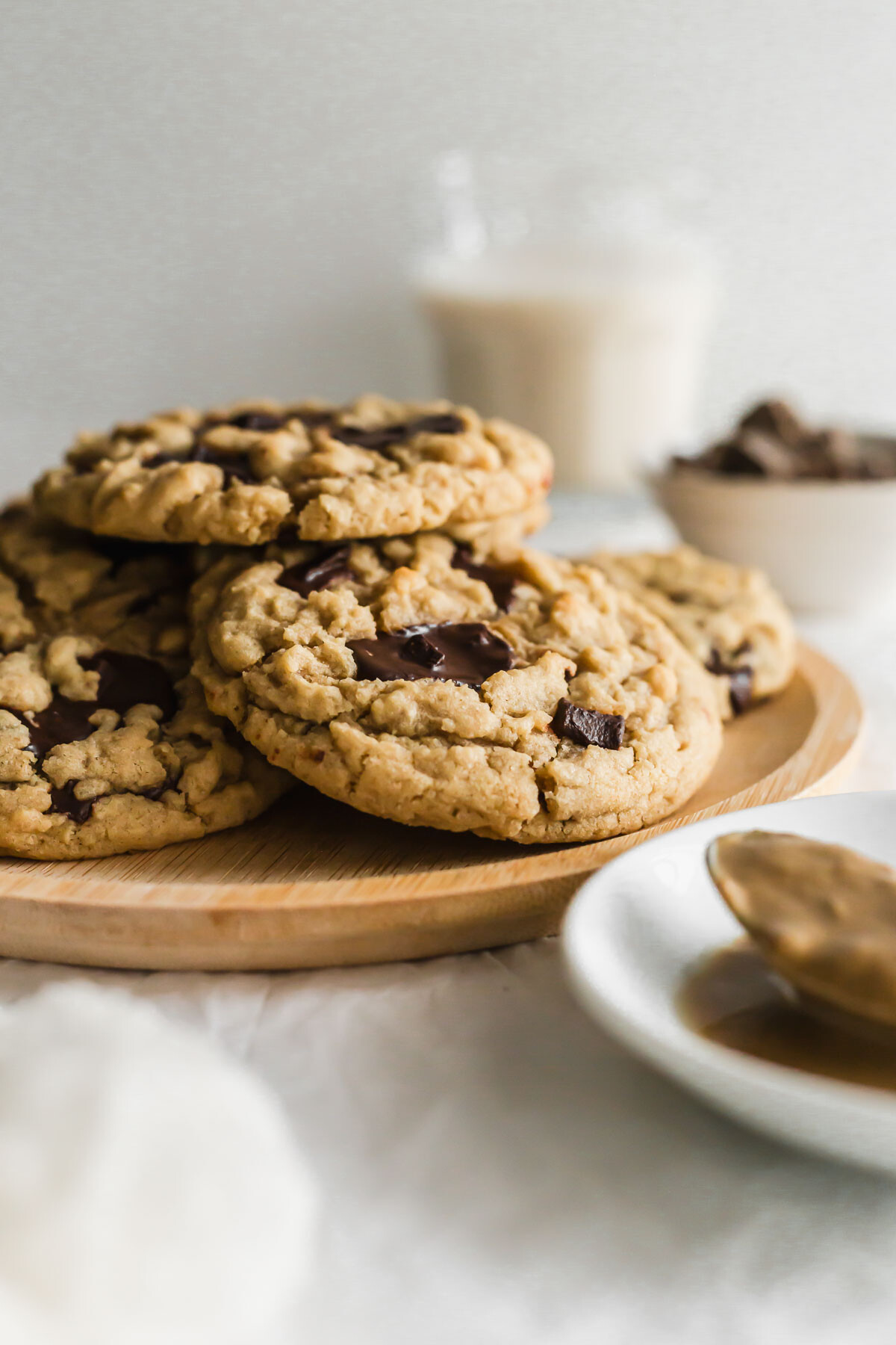 Chocolate tahini cookies on a wooden round plate.
