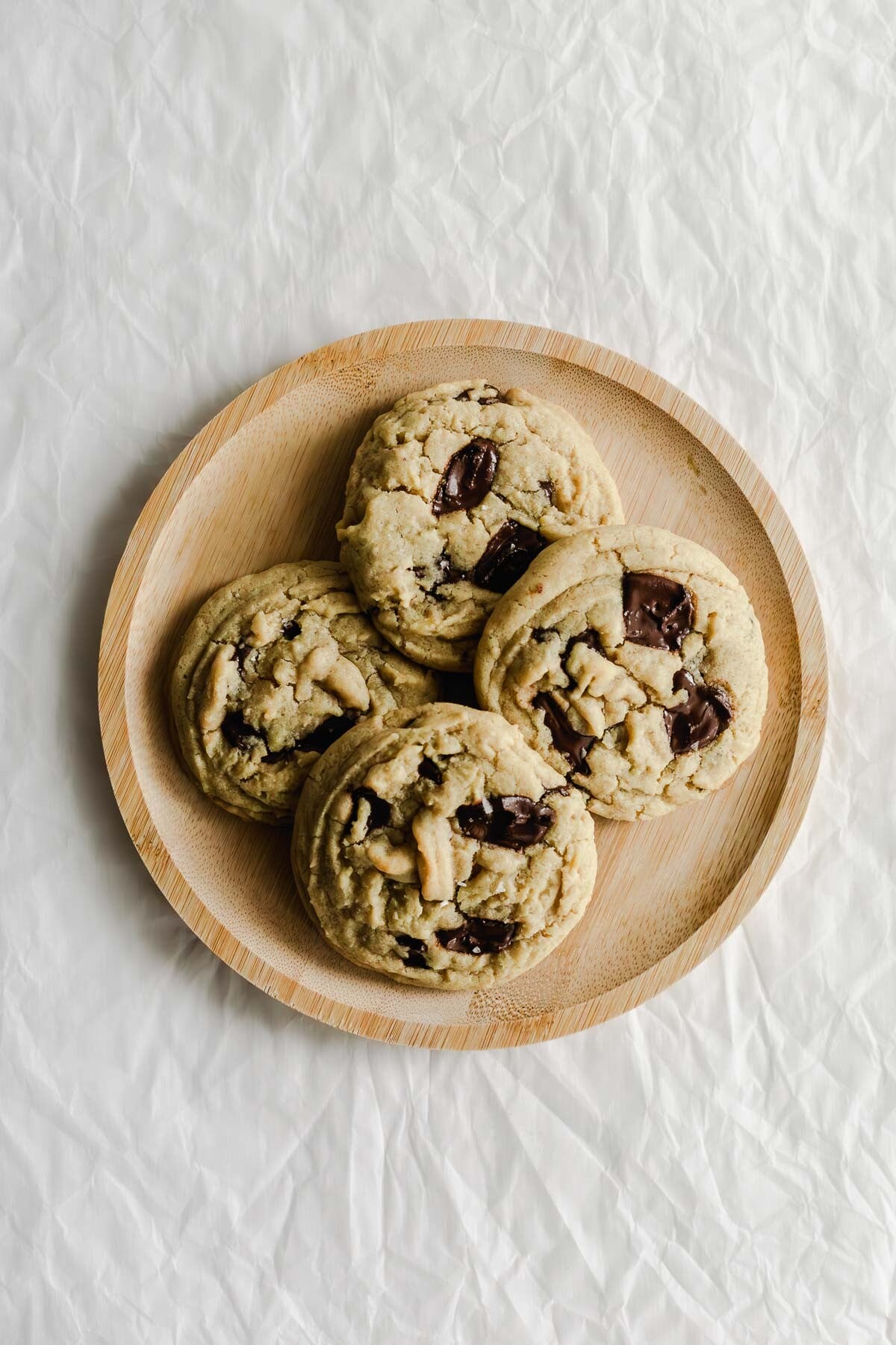 Chocolate chip cookies on a wooden plate.