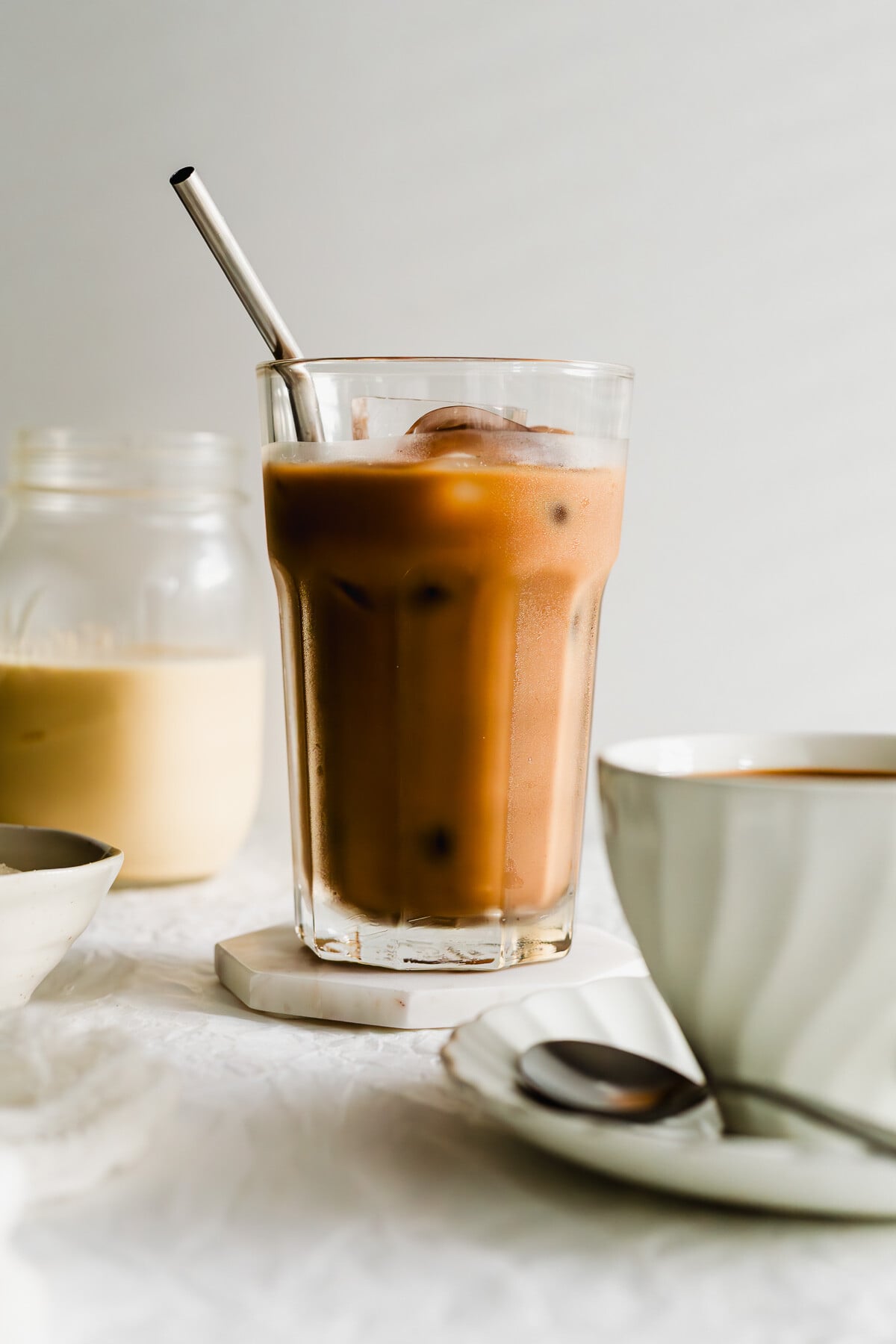 Iced Hong Kong milk tea in a tall glass with metal straw. 
