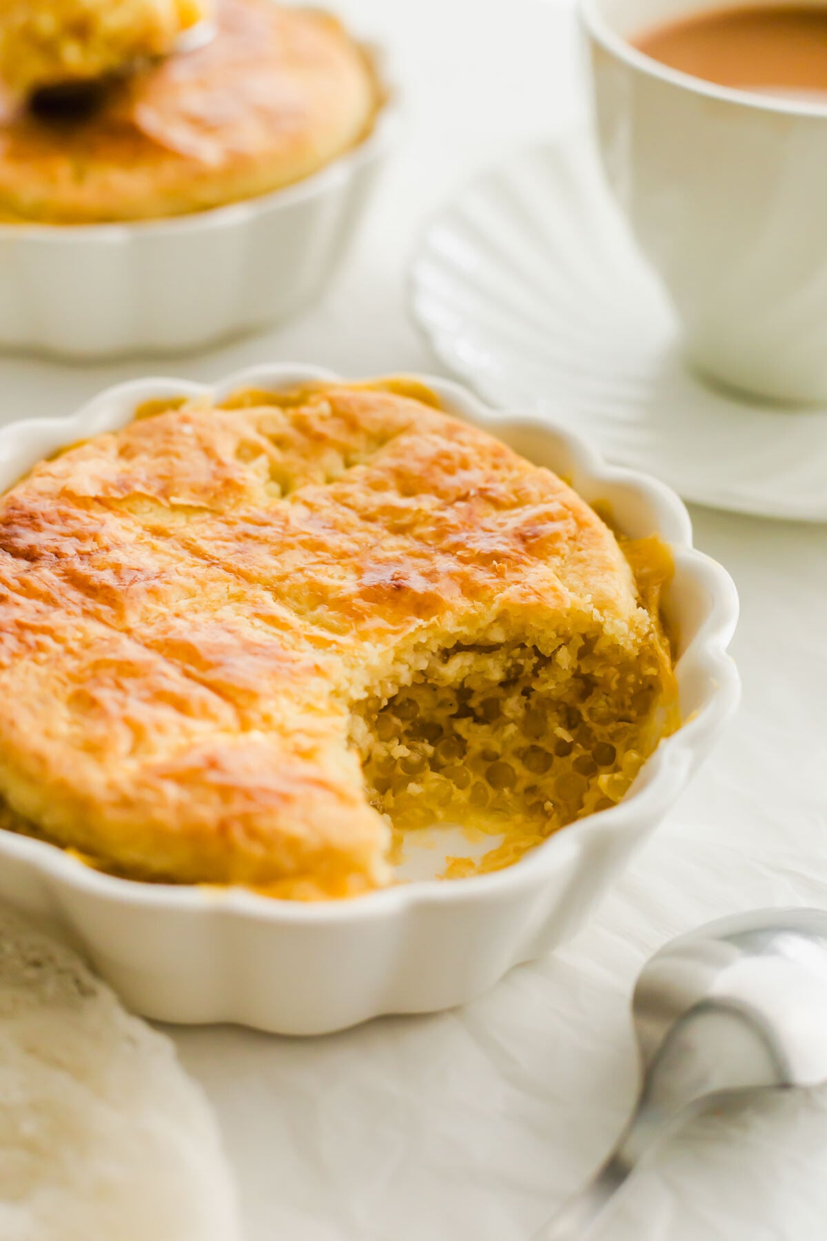 Baked tapioca pudding in a white ramekin, with a scoop removed.