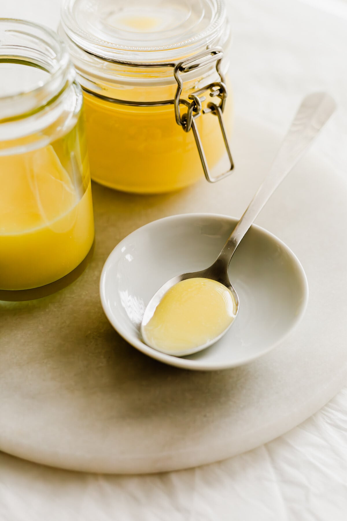 Yuzu curd in a spoon on a small white dish.