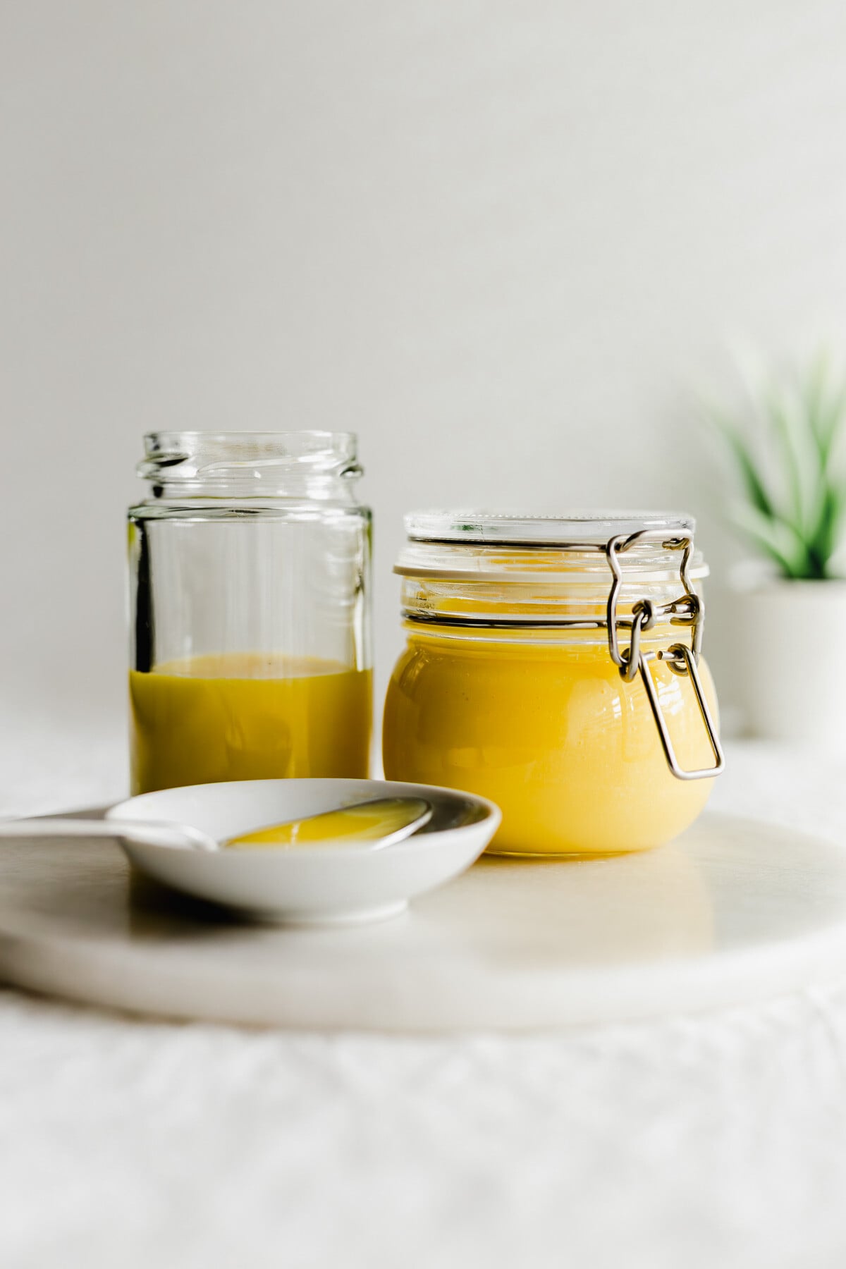 Jars of yuzu curd on a white round marble.