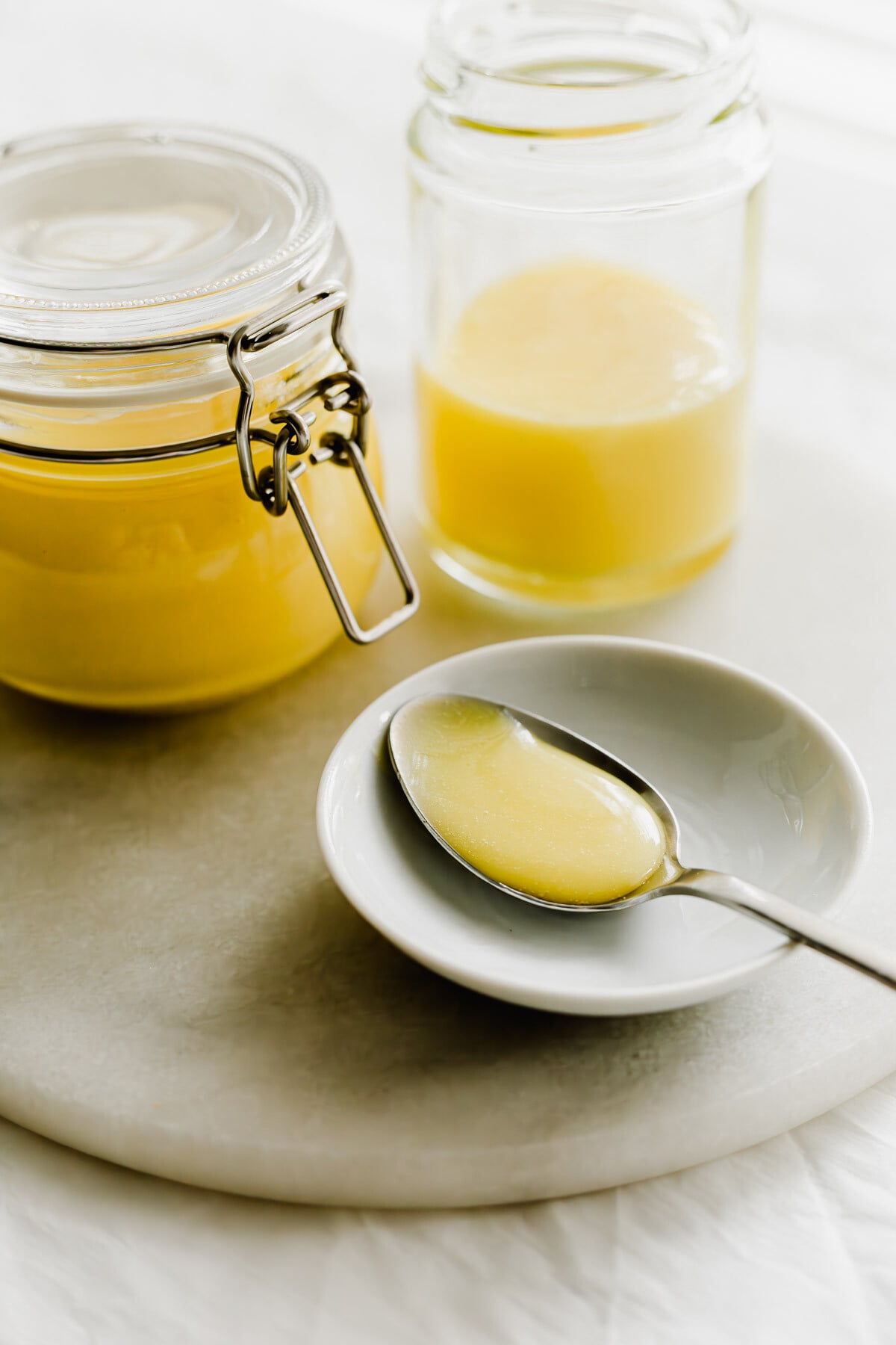 Yuzu curd in a spoon on a small white dish.