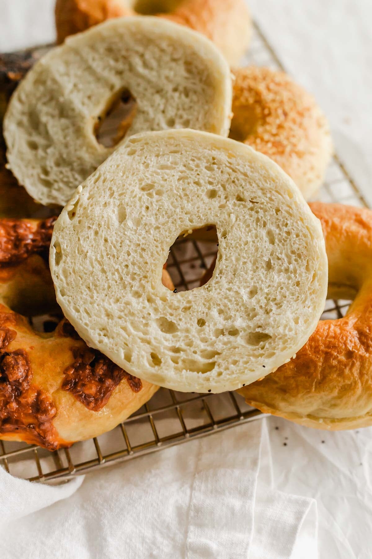 Sliced homemade bagel resting on a wire rack.