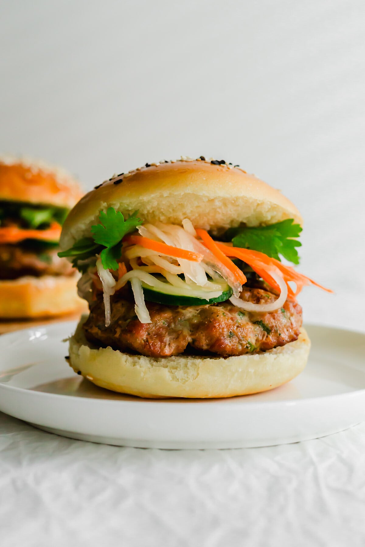 Vietnamese-style banh mi burger on a white plate.