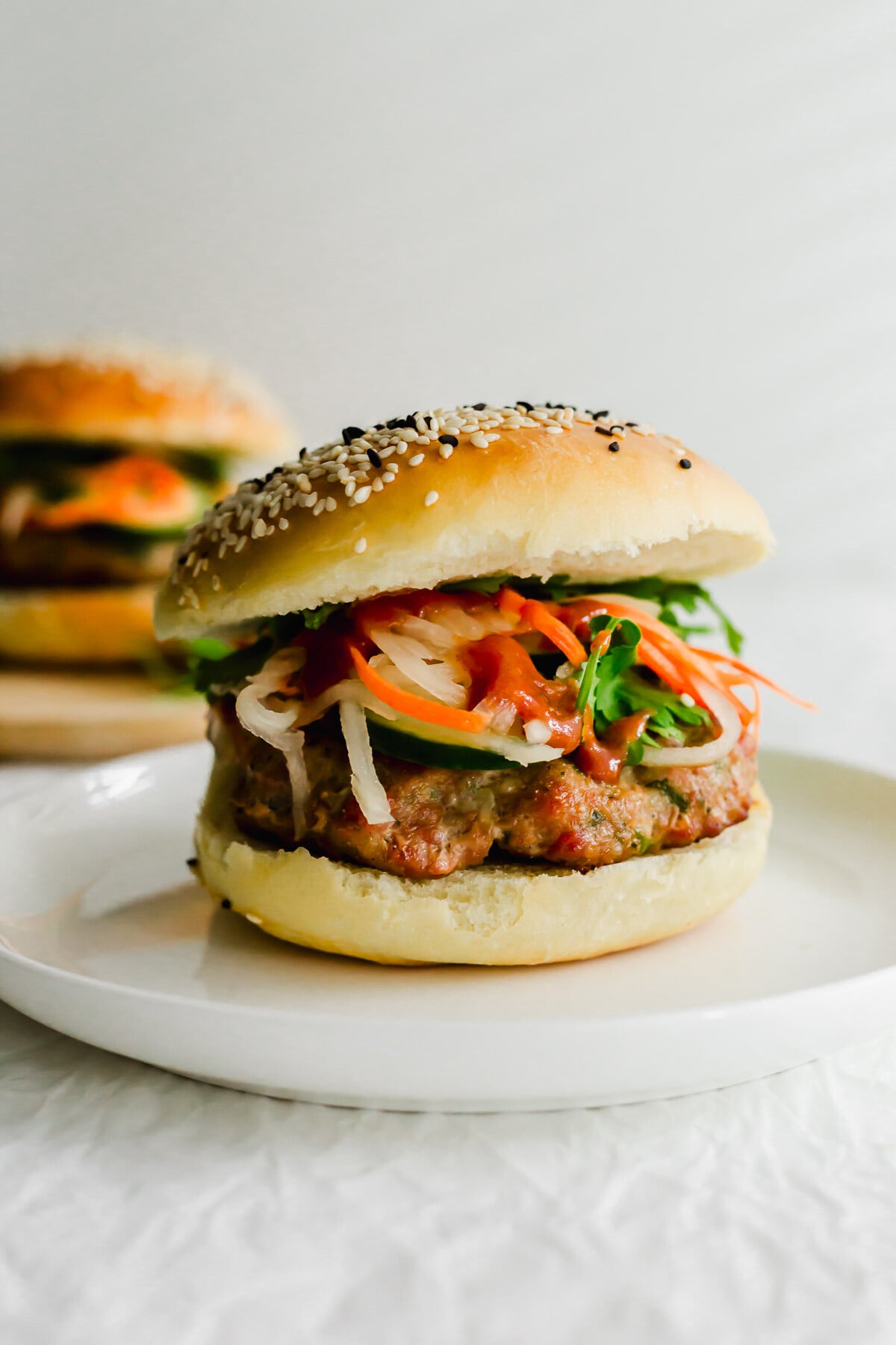 Vietnamese banh mi burger on a white plate.