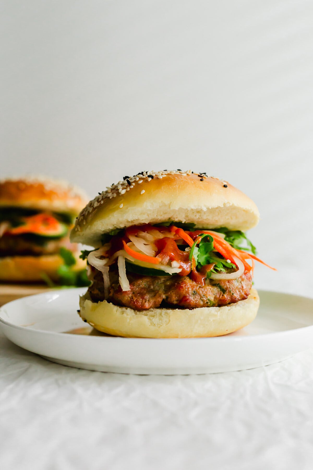Vietnamese banh mi burger on a white plate.