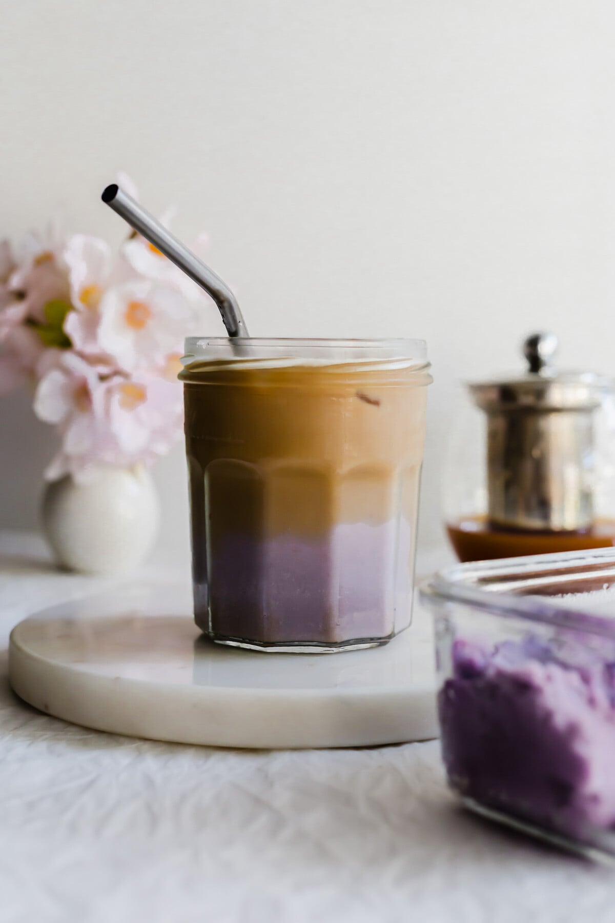 Taro milk tea in a glass jar with metal straw.