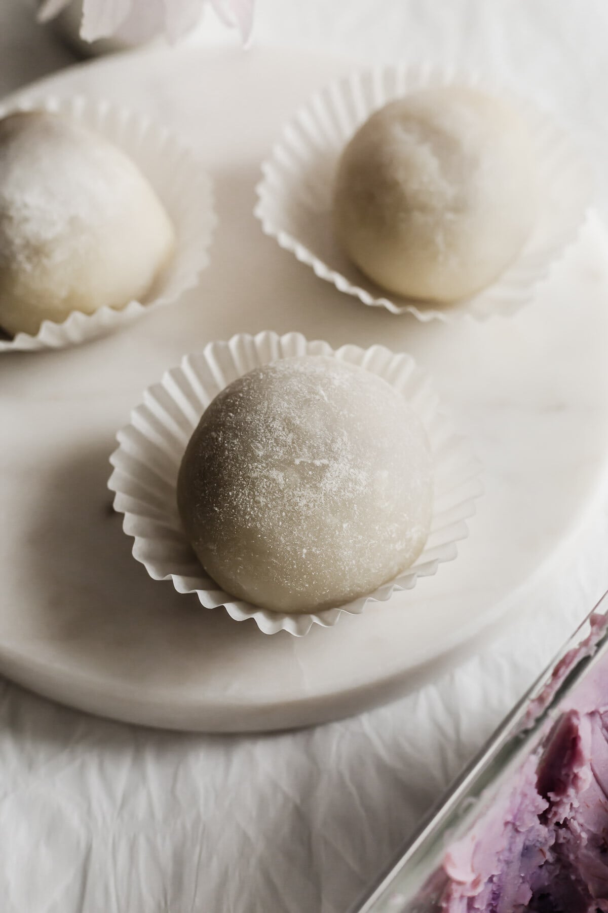Whole taro mochi on a white round marble.